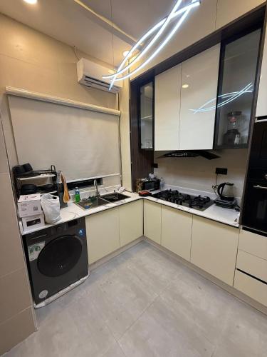 uma cozinha com armários brancos e um aparelho preto em Palm & Pearl Apartment em Lekki