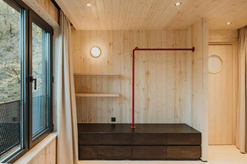 a small sauna with a red pole in a wooden wall at Kiketi Farm Hotels in Kiketʼi