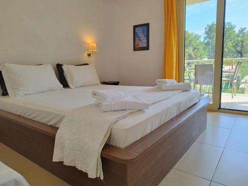 ein Schlafzimmer mit einem großen Bett, auf dem Handtücher liegen in der Unterkunft Esperides Hotel in Limenas