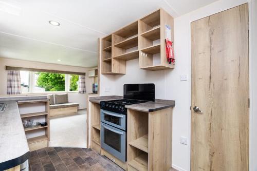 een keuken met houten kasten en een fornuis bij 3 Bedroom Caravan - Seton Sands in Port Seton