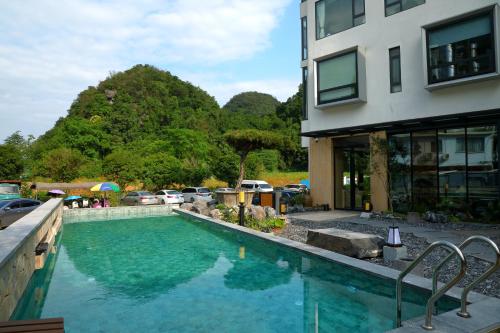 a swimming pool in front of a building at Yangshuo The One Hotel- Aesthetic Lifestyle in Yangshuo