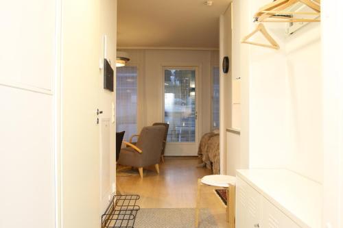 a hallway with a living room with a chair and a table at Arctic Willamo Studio- Rovaniemi in Rovaniemi