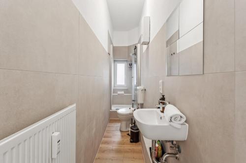 a white bathroom with a sink and a toilet at SHINY HOMES - Modern & Cozy Stay in Bielefeld Mitte in Bielefeld