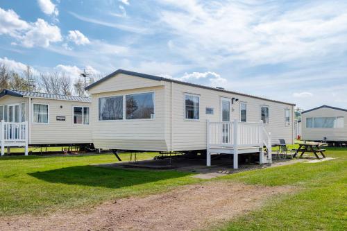 a large white mobile home with a picnic table at 3Bedroom Caravan Seton Sands in Port Seton