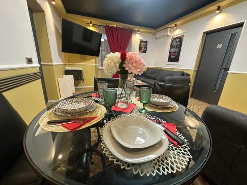 a dining room table with plates and flowers on it at Courtyard Central Premium Apartment in Craiova