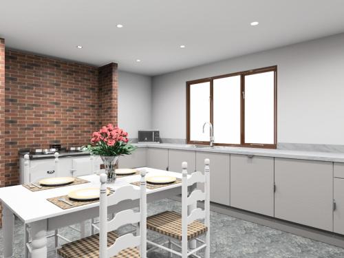 Una cocina con gabinetes blancos y una mesa y sillas blancas. en Glyder Flat - North Wales, en Dolgellau