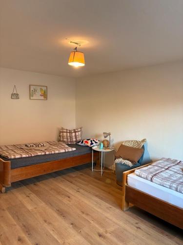 um quarto com duas camas, uma mesa e uma cadeira em Renovated apartment near Büdingen with single beds em Büdingen