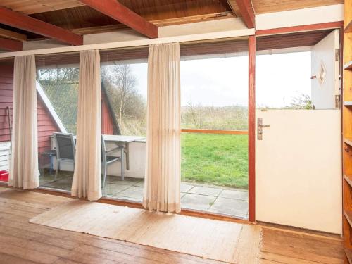 una puerta corredera de cristal abierta en una habitación con patio en 4 person holiday home in Rømø, en Lakolk