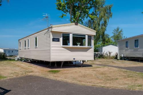 a small white caravan parked in a parking lot at 3 Bed Caravan - Seton Sands in Port Seton