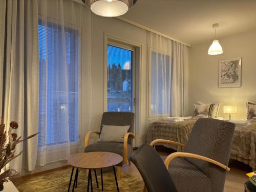 a room with two chairs and a bed and a table at Arctic Willamo Studio- Rovaniemi in Rovaniemi
