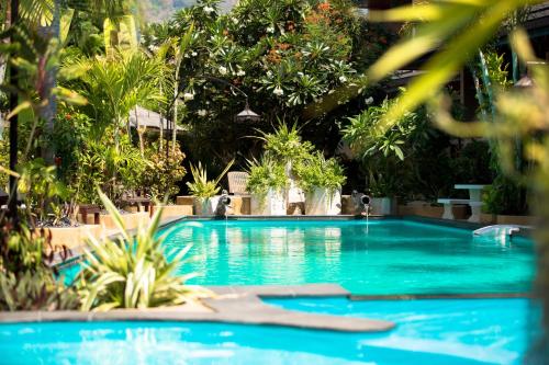 a large blue swimming pool with trees and plants at Aumpai Luxury in Lamai