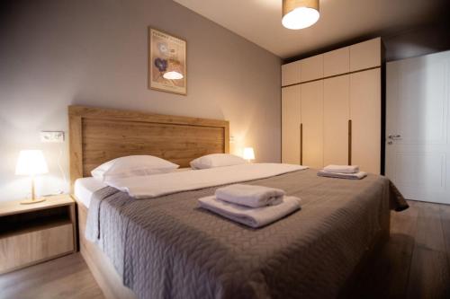 a bedroom with a large bed with towels on it at GGM apartment in Kutaisi