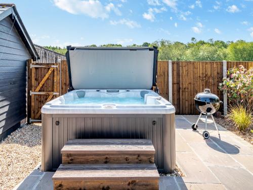 a hot tub in a backyard with a fence at The Farmhouse in Ferndown