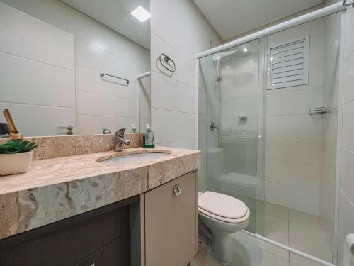 ein Badezimmer mit Waschbecken, Toilette und Dusche in der Unterkunft 2 Dorm a 100 metros do mar in Capão da Canoa