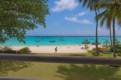 a beach with people and boats in the water at Serge's Beachfront by Serenity in Trou aux Biches