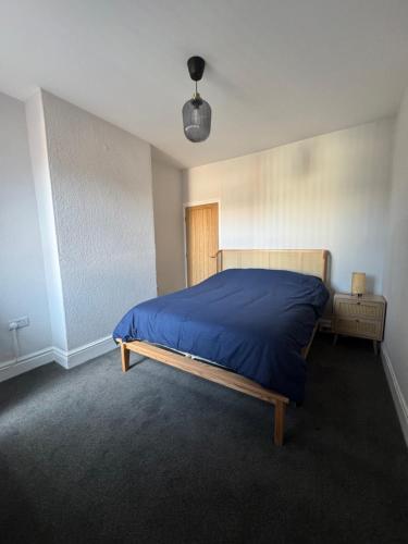 レスターにあるSerenity LTDの青い毛布が掛けられたベッドのある寝室
