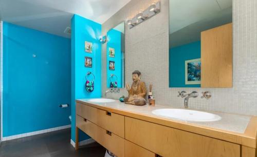 een badkamer met 2 wastafels en een blauwe muur bij Union Station downtown and gameday retreat! in Denver