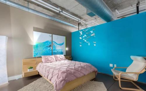 een slaapkamer met een bed en een blauwe muur bij Union Station downtown and gameday retreat! in Denver