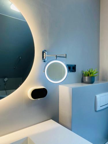 a bathroom with a round mirror and a sink at Nido Vela Appartement in Wesseling