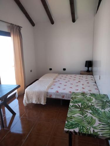 a bedroom with a bed and a table in it at El sueño - Le rêve in San Bartolomé