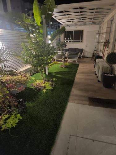 a living room with plants and a green rug at יחידת סאן סנטר באילת in Eilat