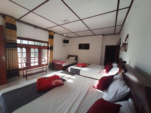 a room with two beds and a couch in it at Green Villa Ella in Ella