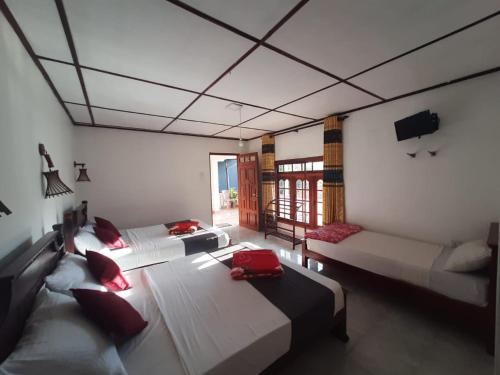 a large room with two beds and a tv at Green Villa Ella in Ella