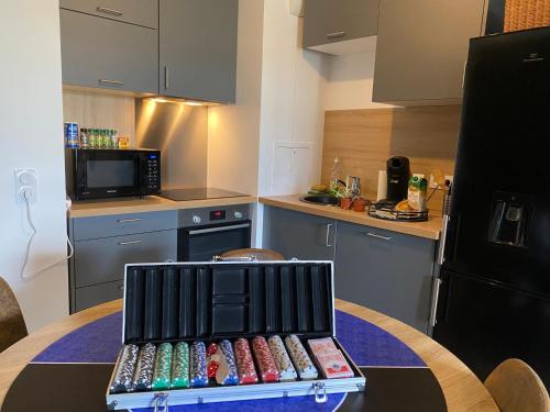Le Vegas في Mantes-la-Ville: مطبخ به طاولة عليها صينية من الدومينو