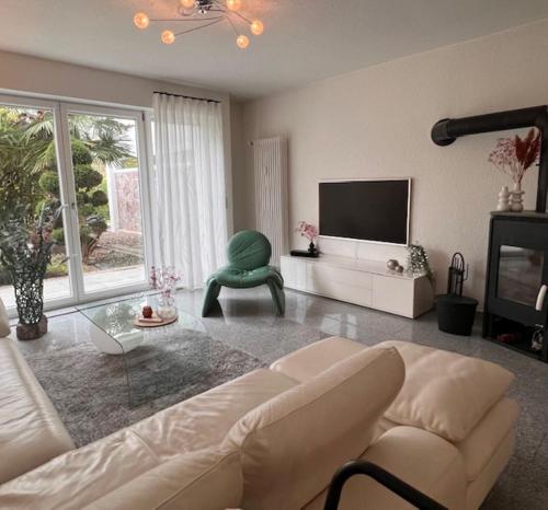 a living room with a couch and a tv at Villa GiNa Apartement in Albbruck