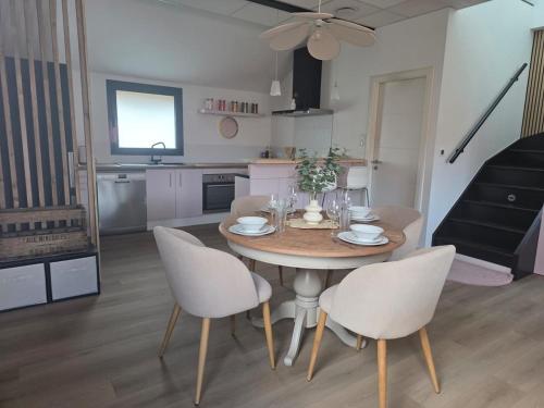 - une table à manger et des chaises dans la cuisine dans l'établissement La Valentine - Appartement proche marché de Noël - Wifi, à La Celle-sous-Gouzon