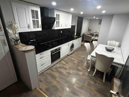 a kitchen with white cabinets and a table with chairs at Appartement in Oberschaeffolsheim