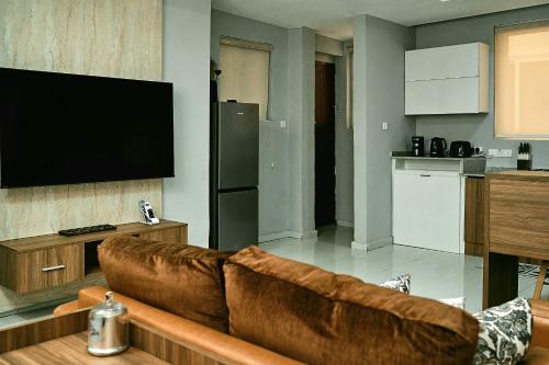 sala de estar con sofá marrón y cocina en The Galleria, en Lagos