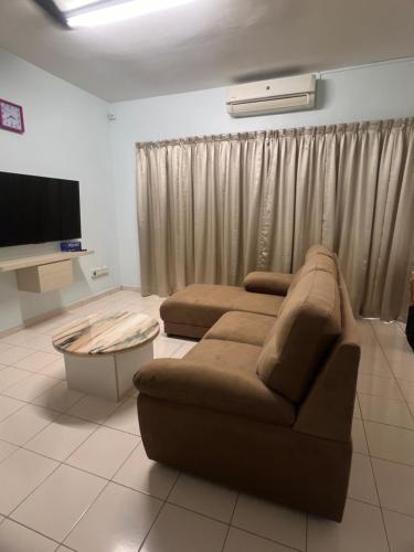 a living room with a couch and a tv at Leaf Haven Homestay in Ipoh