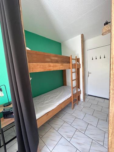 a bunk bed in a room with a green wall at Appartement pour 4 personnes - Piau Engaly in Aragnouet