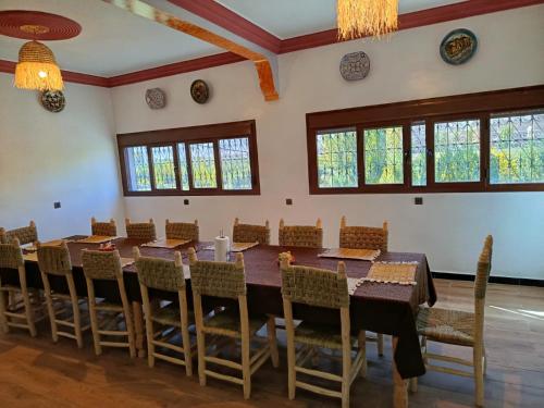 ein Esszimmer mit einem langen Tisch und Stühlen in der Unterkunft Auberge Restaurant Camping Taghzout in Agoudal