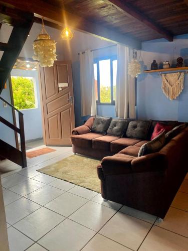 a living room with two brown couches and a door at Apê Beira mar: Ar, mirante e Vista Mar – 6 Pessoas in Imbituba