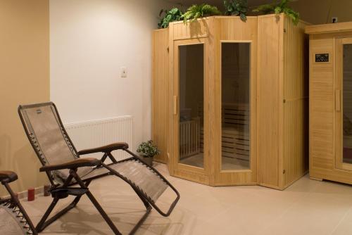 a rocking chair in a room with a wooden cabinet at Hotel Harmonie in Luhačovice