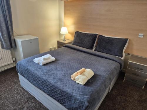 a bedroom with a bed with two towels on it at Osterley Park Hotel in Syon Lane Station