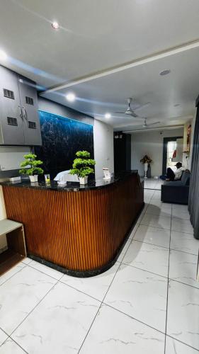 a lobby with a bar with plants on it at Hotel RD in Kadi