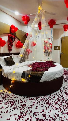 a bedroom with a bed with red balloons on it at Hotel RD in Kadi