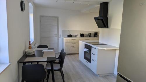 a kitchen and dining room with a table and chairs at Moderne 3-Zimmer-Ferienwohnung direkt am Saaleradwanderweg in Halle an der Saale