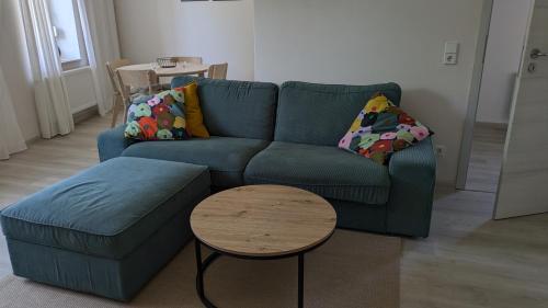 un salon avec un canapé bleu et une table dans l'établissement Moderne 3-Zimmer-Ferienwohnung direkt am Saaleradwanderweg, à Halle-sur-Saale