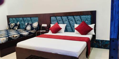 a bedroom with two beds with red pillows at Ram Sevak Hotel By Nandan in Ayodhya
