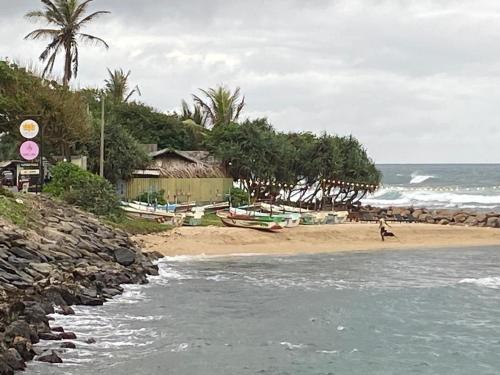 - une plage avec une personne se promenant sur le sable dans l'établissement Costal View, à Ahangama
