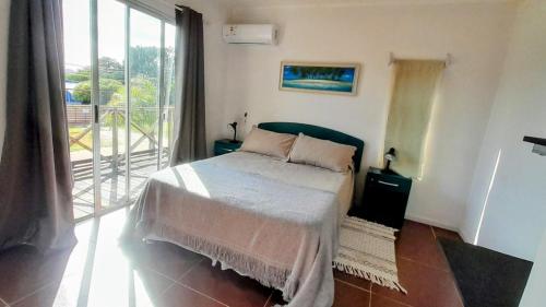 une chambre avec un lit et une grande fenêtre dans l'établissement GreyStone, à Balneario Buenos Aires