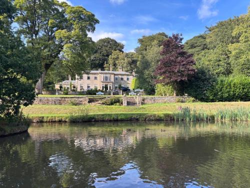 a house with a pond in front of it at Park Hall Manor in Hayfield