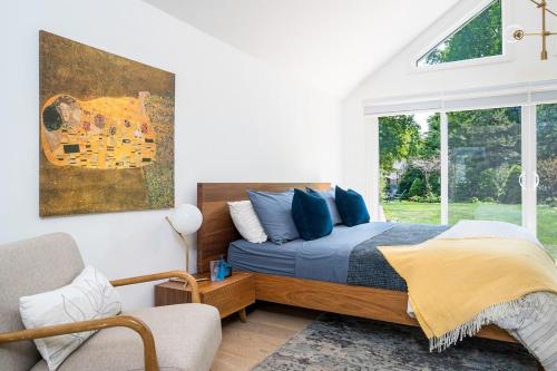 une chambre avec un lit avec des oreillers bleus et une fenêtre dans l'établissement Driftwood on 6th Heritage Downtown Collingwood, à Collingwood