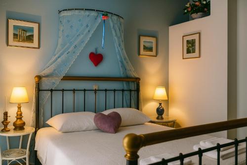 KástronにあるPolytropon Apartmentsのベッドルーム1室(壁にハートを配置したベッド1台付)