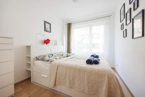 a white bedroom with a bed and a window at Stylish City Stay in Budapest