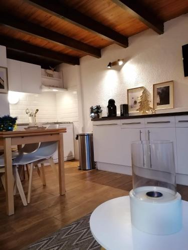 une cuisine avec une table et un verre de vin dans l'établissement Les Chalets de Mel, à Saint-Lary-Soulan